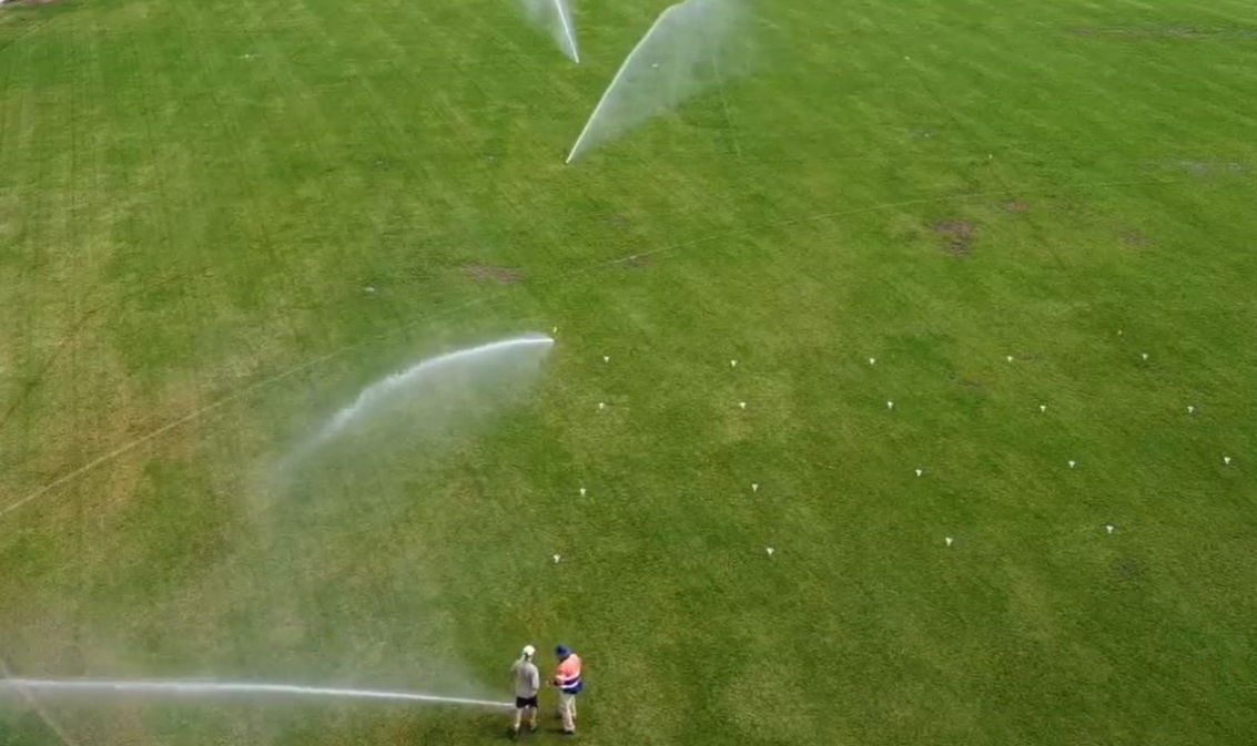 Birds eye view image of a community sporting field being irrigated