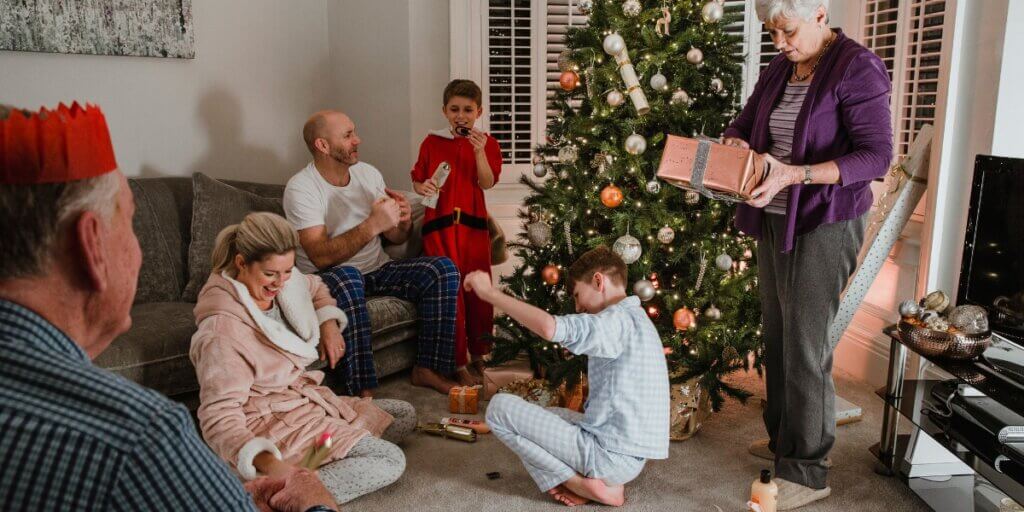 People giving presents around the Christmas tree