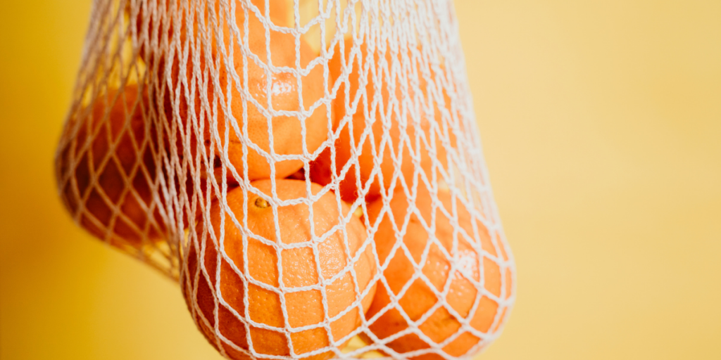 A reusable bag full of oranges