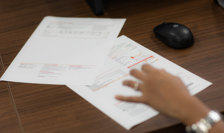 Female hand sifting through energy bills on a desk