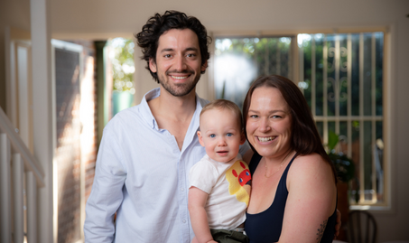 Cardvarski family standing in living room, smiling into camera