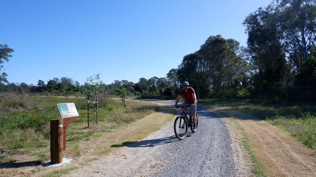 Man riding bike through wide gravel path