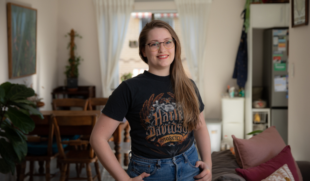 Alexandra standing in her living room, smiling looking into the camera.