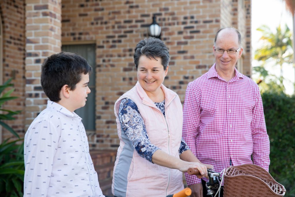 The Blumke family outside their home, standing next to and holding their bicycles.