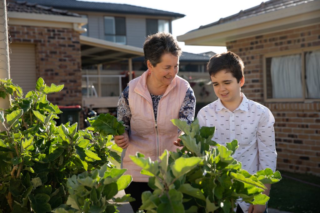 Lisa Blumke showing her son their vegetable garden