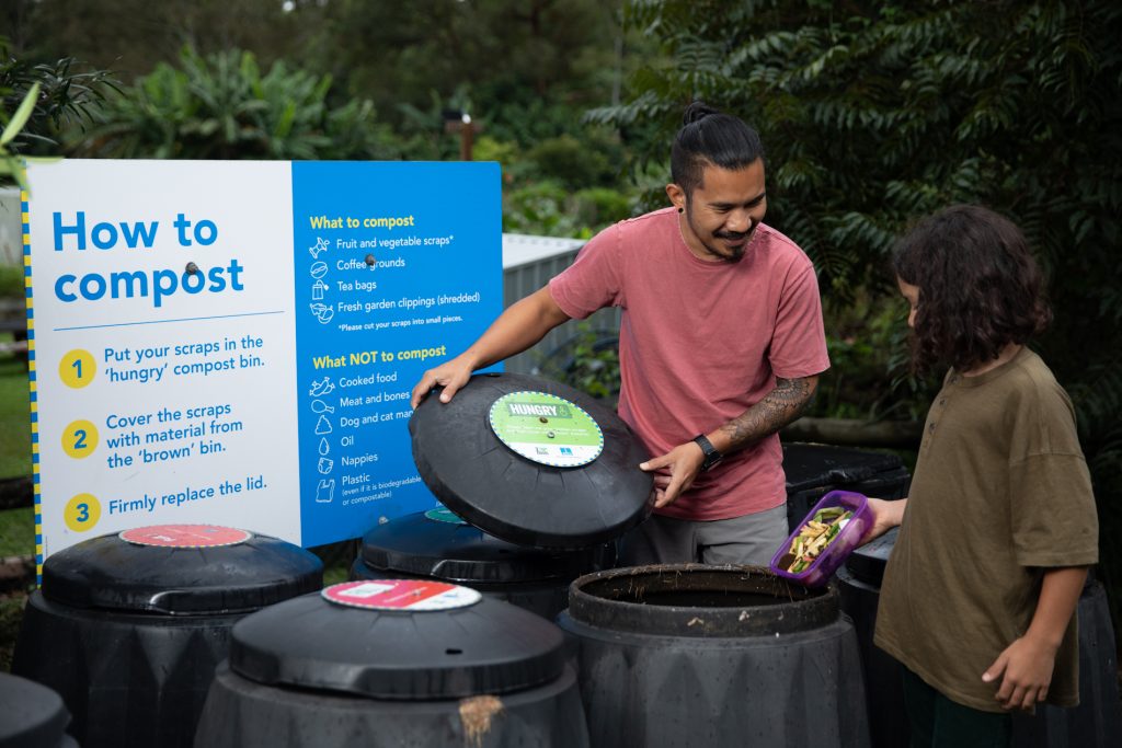A father and son composting at a community hub