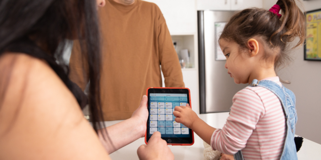 The Jackson family showing their daughter the smart home energy device buttons on their iPad.
