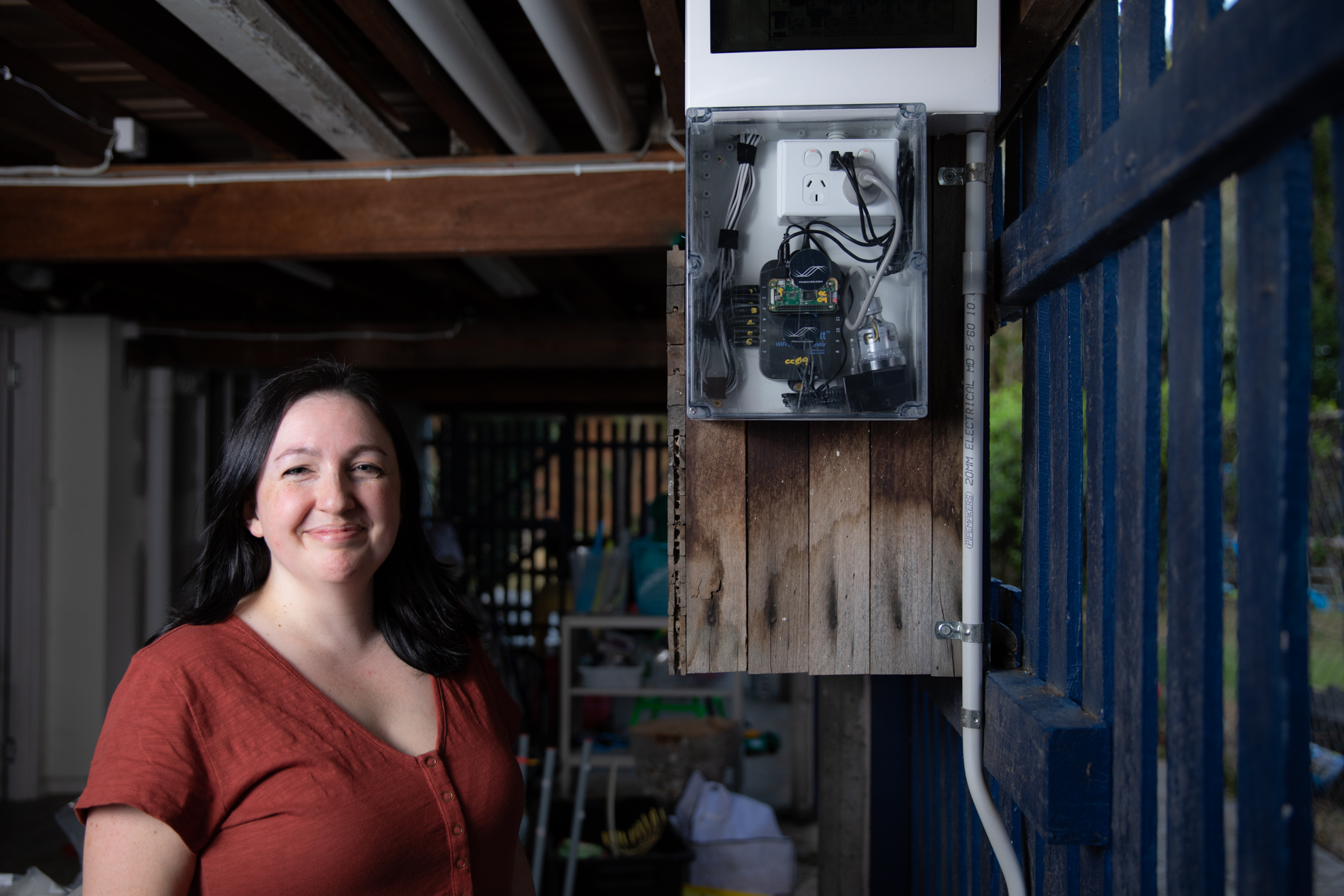 Emma Boyd standing next to her home energy monitoring system