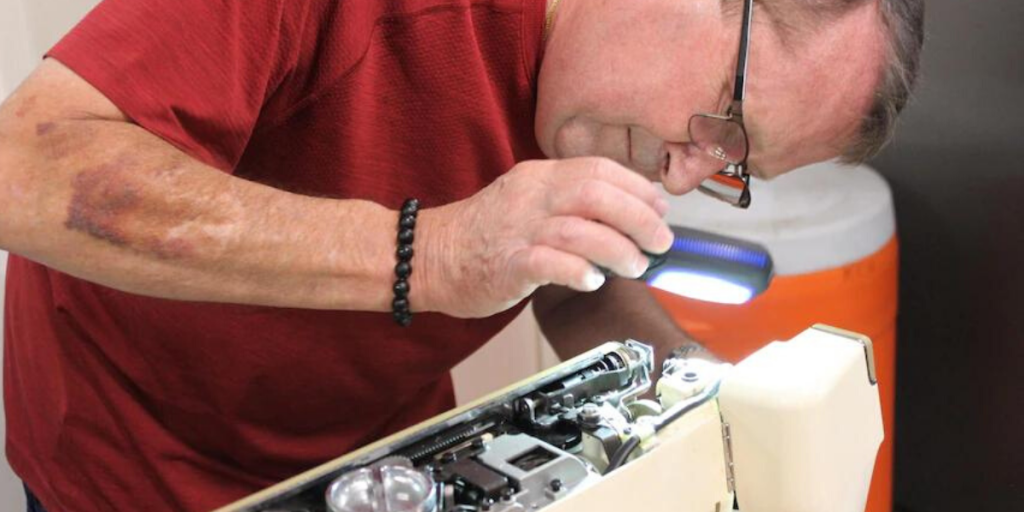 Repair cafe volunteer inspecting the insides of 