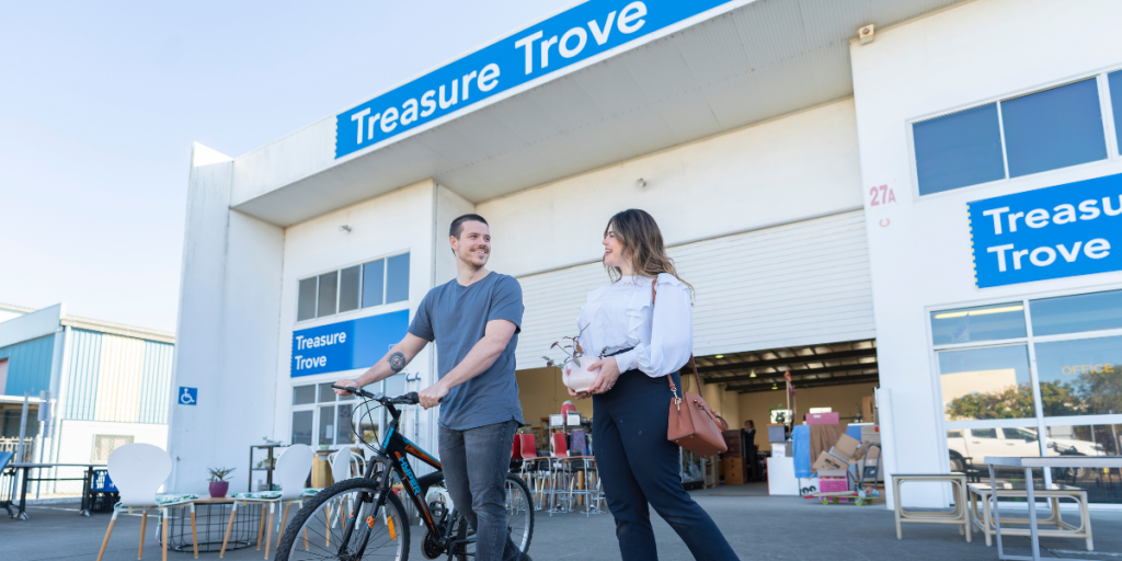 Two people with a bike outside the Treasure Trove