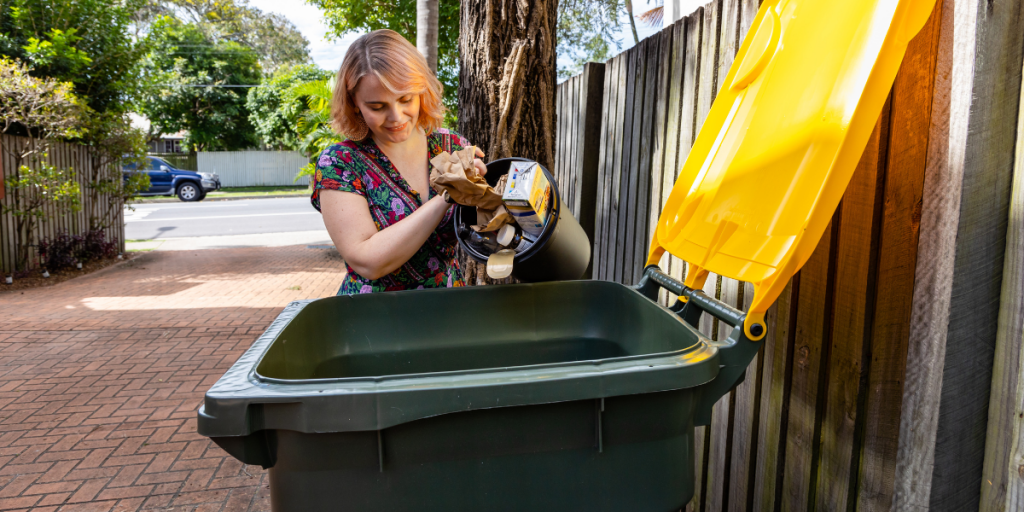 A lady with her yellow top recycling bin