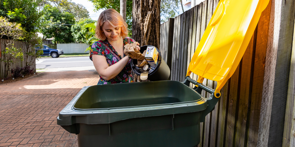 A lady emptying items into her recycling bin