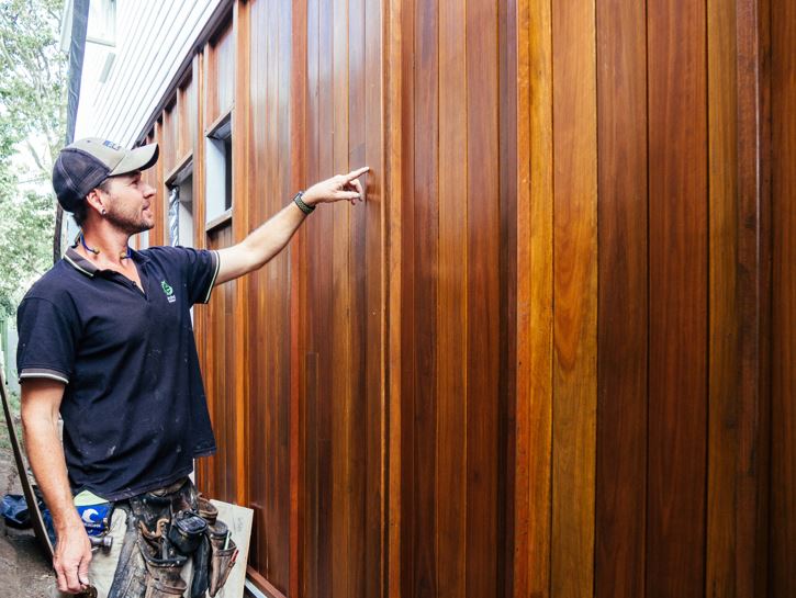 Builder inspecting hardwood external cladding of a house being constructed