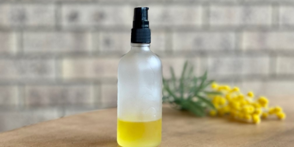 A bottle of beard oil with wattle in the background