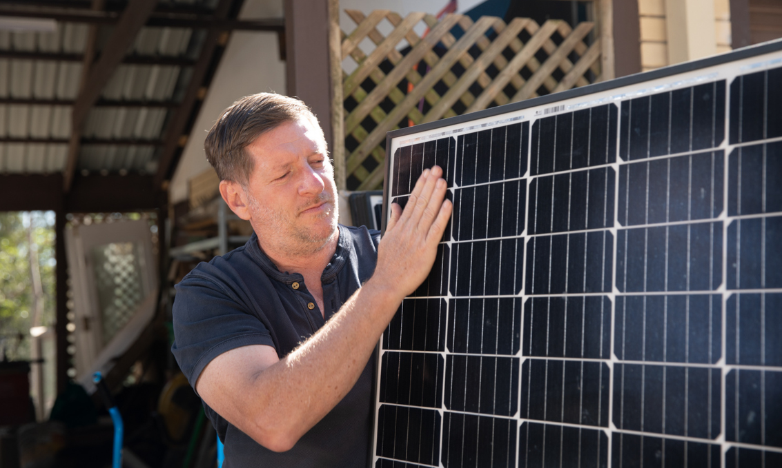 Man holding and looking at solar panels.