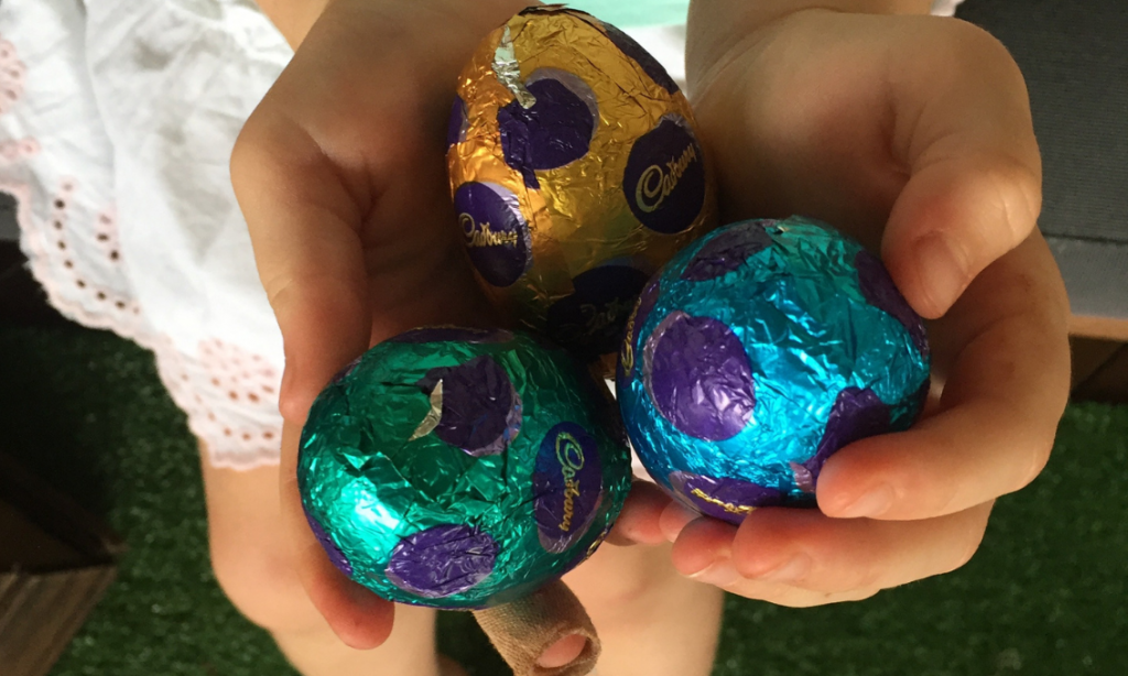 Wrapped Easter eggs held in child's hands