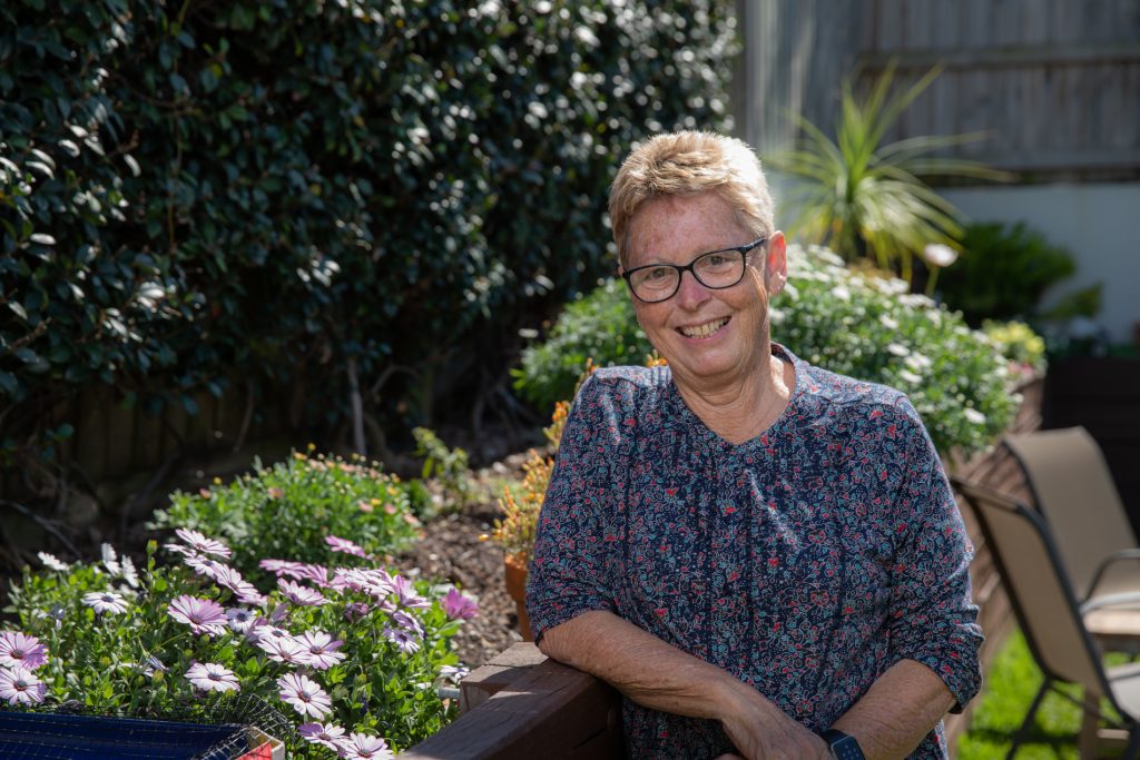 Woman smiling while in her garden.