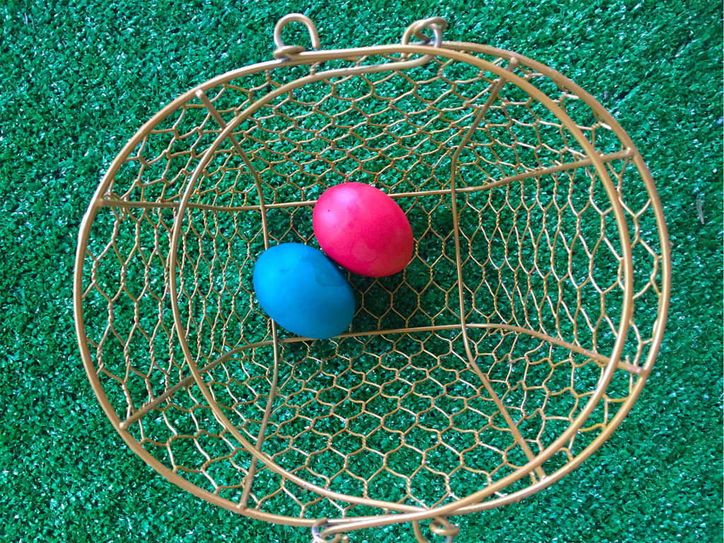 Dyed Easter eggs in a wire basket for an Easter egg hunt