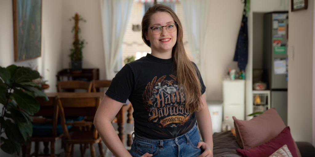 Alexandra standing in her living room, smiling looking into the camera.