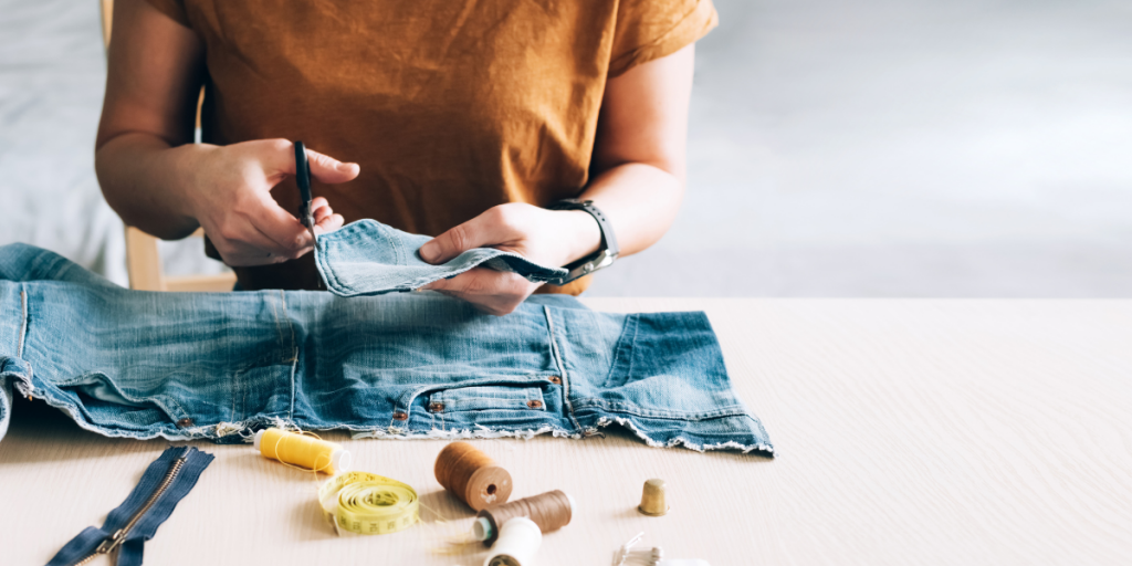 person cutting fabrics and amending clothing