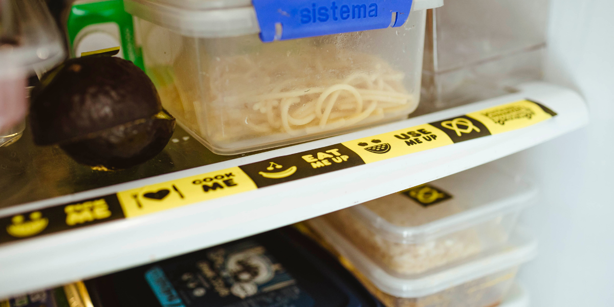 food containers in fridge with 'use it up' labels on them.