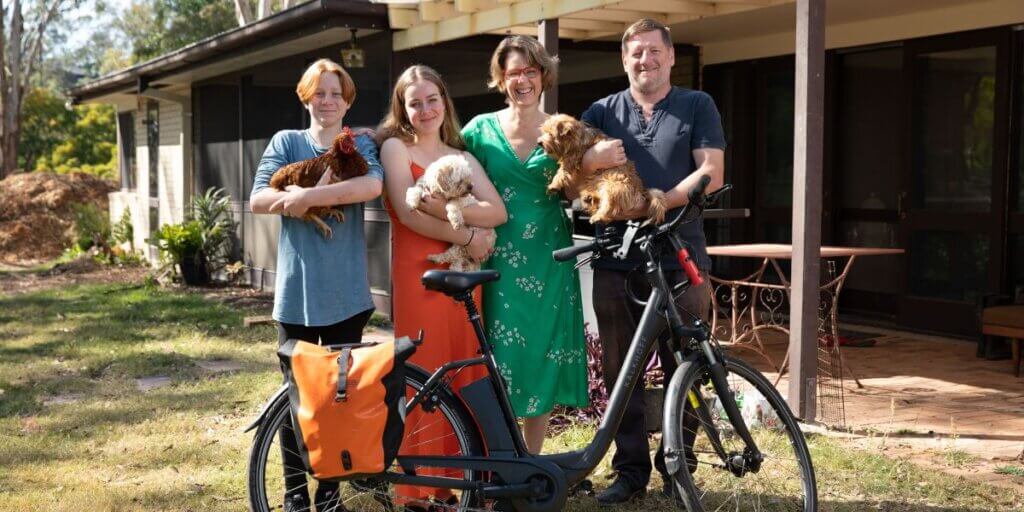 Family of four standing behind a bicycle