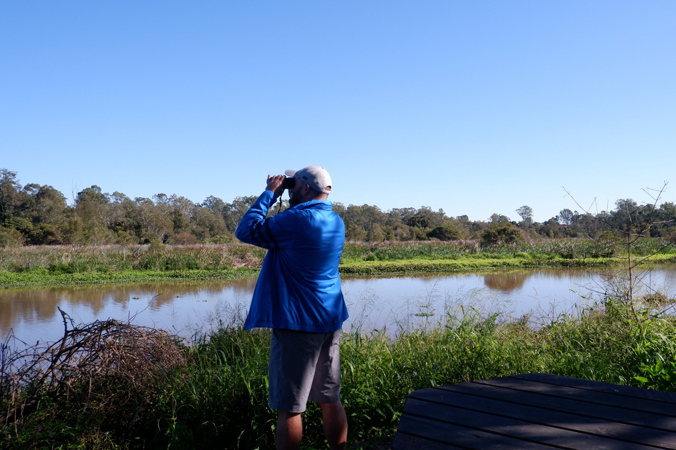 Man overlooking lake through binoculars